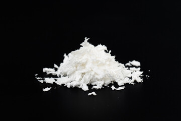 a pile of poured white artificial synthetic snow on a black background