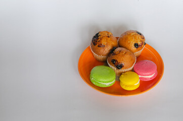 desserts for coffee and tea. Macaroons, meringues and cupcakes on a light background