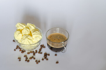 A cup of coffee, a delicate meringue dessert and coffee beans on a light background