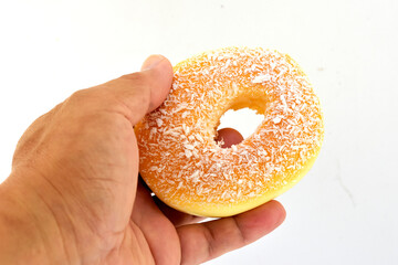 The large, yellow donut looks delicious in the customer's left hand. 