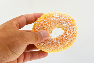 The large, yellow donut looks delicious in the customer's left hand. 