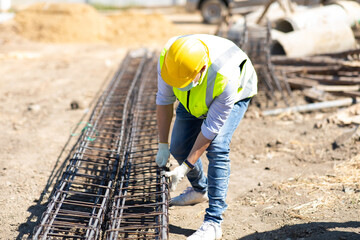 Asian construction worker on building site. fabricating steel reinforcement bar. wearing surgical face mask during coronavirus and flu outbreak