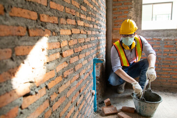 Asian man construction worker holding pipe and working on site.