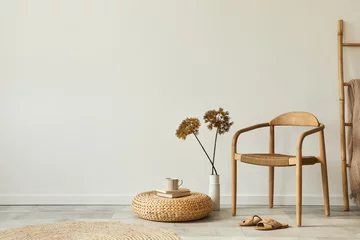 Fotobehang Boho Neutral concept of living room interior with design wooden chair, round carpet, dried flowers in vase, stool, slippers, decoration and elegant personal accessories. Template. Copy space.  © FollowTheFlow