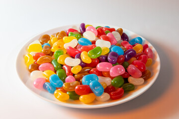 A plate of colourful Jelly Beans on a white background