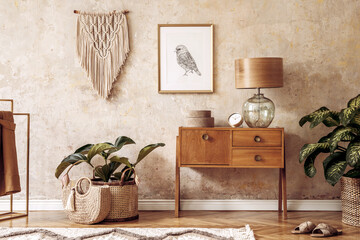Modern retro composition of living room with wooden vintage commode, furniture, lamp, plant, carpet, pillows, gold mock up poster frame, plants, decoration and personal accessories.