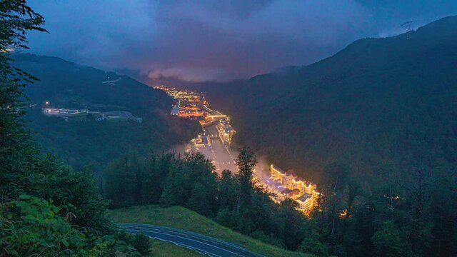Time lapse video. Aerial view - evening at the Rosa Khutor ski resort. Fog dissipating after rain, beautiful mountain evening landscape