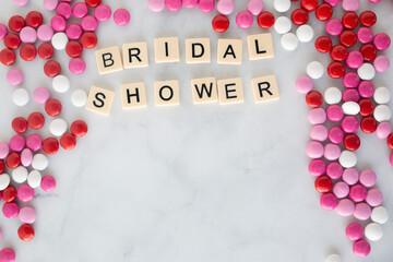 the words bridal shower written in scrabble tiles on a marble kitchen counter top surrounded by valentines candy