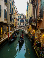 Gondolas and festive Christmas decorated shops in a quiet side canal in Venice