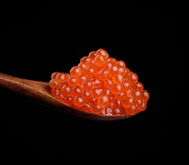 fresh grainy red chum salmon caviar in a wooden spoon, delicious and healthy food