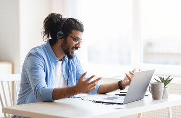 Web Conference. Arabic Freelancer Guy In Headset Making Video Call On Laptop