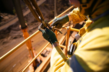 Safe work practices top view of rigger crane high risk worker wearing a safety glove fastening pin...
