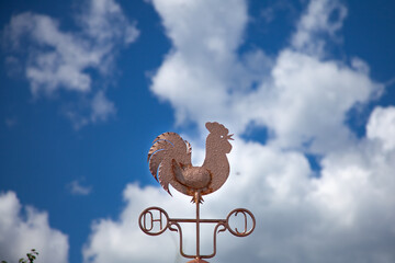 great photo. summer time. sunlight. photo from bottom to top. weather vane in the form of a golden...