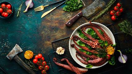 Baked octopus with spinach, lemon and parsley on a baking sheet. Top view. Flat lay.