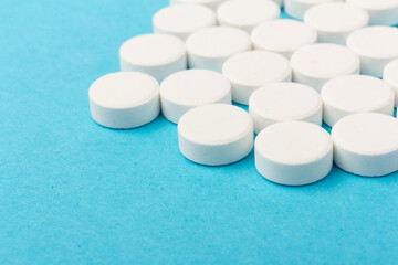 Heap of pills on blue background. Medicine, pharmacy and health concept.