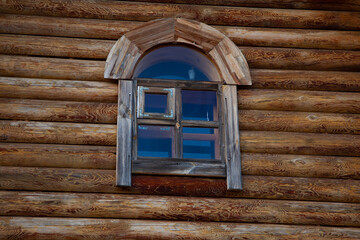 large horizontal photo. summer time. Russia. old wooden window in the wall of a log house. solid wood wall varnished.