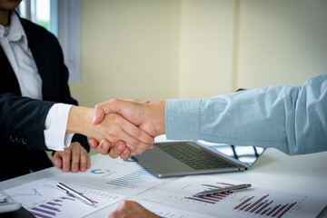 female finance staff is shakeing hands to congratulate With her business man leader because she has made profits grow a lot in the past month, the finance company profits concept