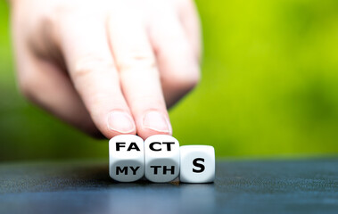 Hand turns dice and changes the word myths to facts.
