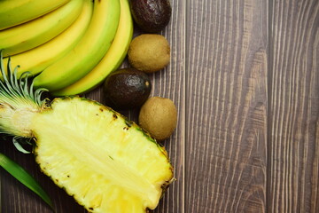 Assorted tropical fruit on brown wood. Space text or idea.