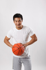 A young man playing basketball in casual clothes