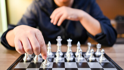 Businessman hand or chess player moving chess piece on chessboard game defeating the king....