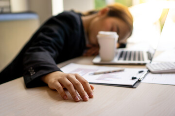 An Asian female finance worker was asleep at her desk and notebook as she worked overtime until...