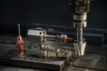 The sinker EDM machine operation with mold insert part. The 4-axis EDM machine control by CNC program.