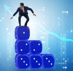 Businessman balancing on top of dice stack in uncertainty concep
