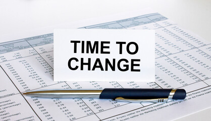 Text Time To Change on white card with blue metal pen on financial table