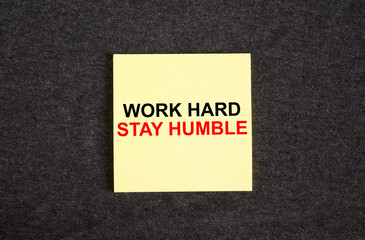 Yellow sticker on the dark gray texture background with text Work Hard Stay Humble