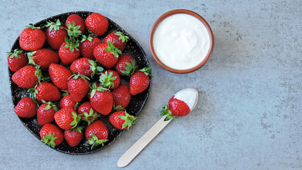 Ripe juicy strawberries on a plate and cream. Healthy dessert strawberry with cream.
