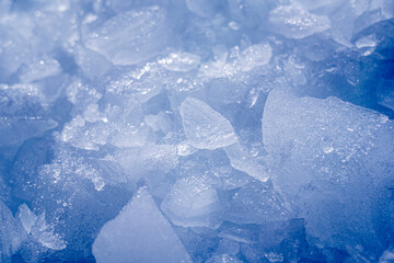 Amazing blue abstract broken ice crystals texture. Frozen background of ice closeup. Copy space. Macro photo