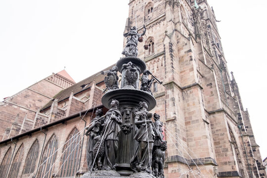 Statues In Nurnberg City Center. There Are Lots Of Mothers Who Are Flushing Water From Their Breasts. There Are Children On Second Floor And They Are Playing Musical Instruments. And There Is A Woman 