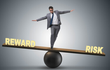 Businessman balancing between reward and risk business concept