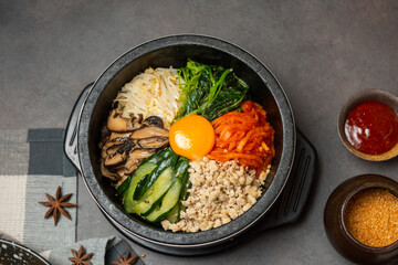 Bibimbap korean food. Korean Bibimbap Mixed Rice with egg,  vegetable, kimchi, mushroom and pork chop in black bowl. Korean food concept.