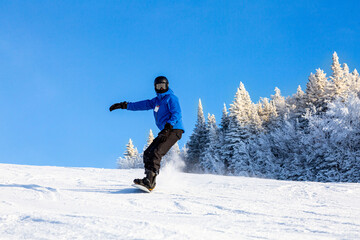 Snowboarder going down the slopes and having fun in the French Alps, France. Concept about...
