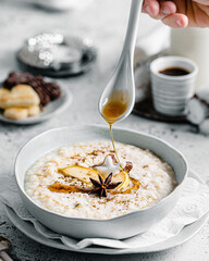 Rice porridge with maple sirup drizzle - obrazy, fototapety, plakaty