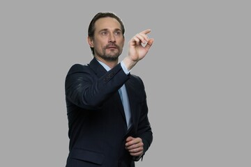 Successful businessman touching virtual screen. Handsome male CEO using transparent virtual screen. Business and future technology concept.