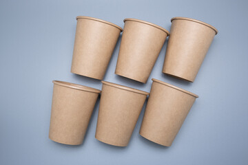 Disposable paper cups on a gray background. Environmentally friendly product.