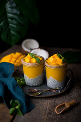 Homemade healthy breakfast, chia pudding with coconut milk and mango on a wooden