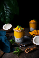 Homemade healthy breakfast, chia pudding with coconut milk and mango on a wooden