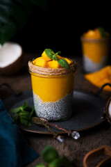 Homemade healthy breakfast, chia pudding with coconut milk and mango on a wooden