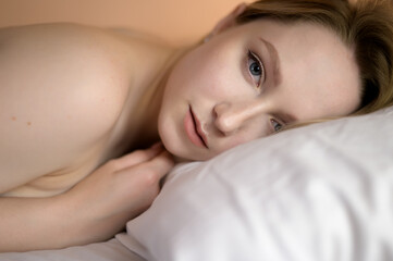 Fototapeta na wymiar Closeup portrait of a beautiful young lady lying on the bed.