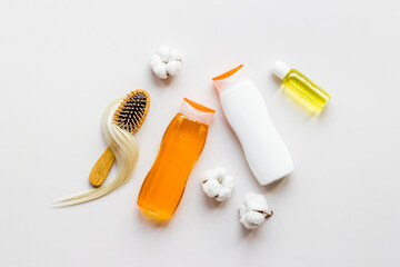 Top view of female hair care set with comb, shampoo and essential oil