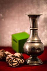 still life with walnuts, pewter vase and green cube