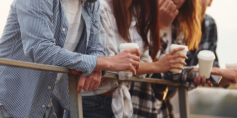 Fototapeta premium Close up view. Group of young cheerful friends that is outdoors having fun together