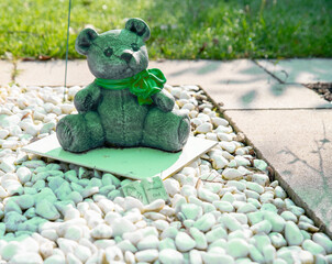 Teddy mit Schleife auf einem Kindergrab © Blende8
