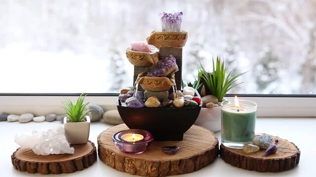 Relaxing spiritual Feng Shui altar set with nature, water and fire element. Tabletop small electrical fountain with water pouring cups. Symbol of wealth and prosperity. 