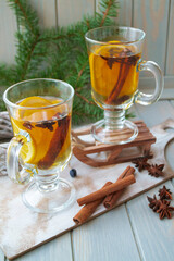 Hot tea in glass with spices on a wooden background. Still life, seasonal and holidays concept