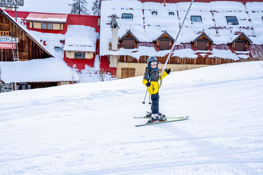 Auron, France 31.12.2020 A boy lifting on the ski drag lift rope in bright sport outfit over sun light on the ski resort mountain. Hight quality photo